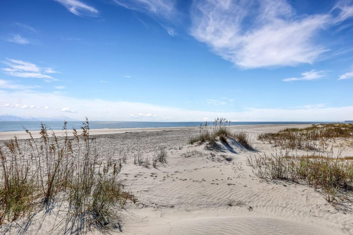 View of East Beach on St. Simons Island with sandy dunes, sea oats, and the Atlantic Ocean as seen from Coast Cottages.